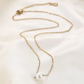 Collier La Perle de Foi de la marque MoonRose avec pendentif or et perle élégante, porté sur un modèle.
