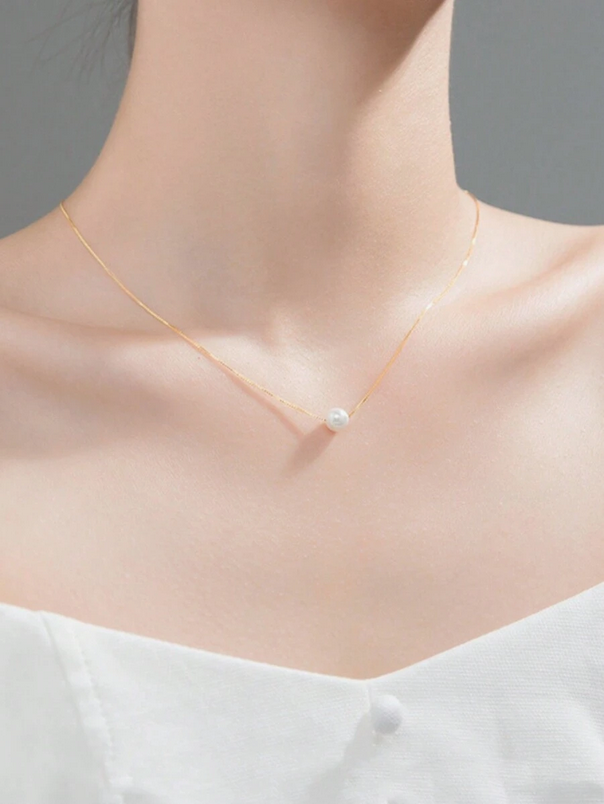 Collier La Perle de Foi de la marque MoonRose avec pendentif or et perle, suspendu à une chaîne fine en or.